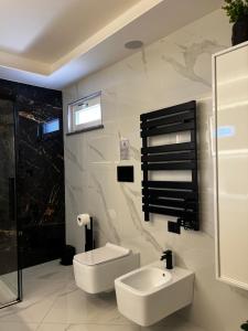 a white bathroom with a sink and a toilet at Green House in Vico Equense