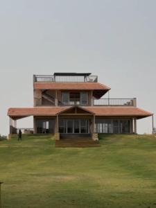 a large house with a green field in front of it at Rathi property in Gurgaon