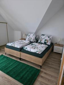 a bedroom with two beds and a green rug at ŁeboVe ZaCisze Spa & Relax in Łeba +26 photos