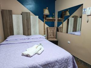 a bed with two white towels on top of it at Hotel Las Lomas de Pisco in Pisco