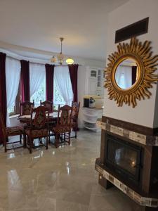 a dining room with a table and a mirror over a fireplace at ŁeboVe ZaCisze Spa & Relax in Łeba