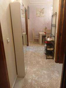 a hallway with a mirror and a room with a table at App de luxe sur complexe ATANMIYA de MARTIL in Martil