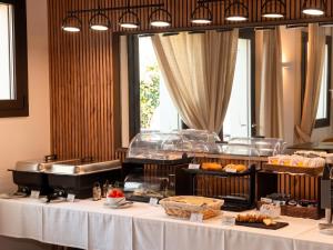 a buffet line with a table with bread and pastries at Hotel Scala - Buongiorno! Hotels in Treviso