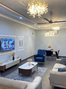 a living room with couches and a dining room at Modern Three-Bedroom Apartment in Accra
