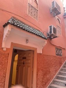 a pink building with a door and some stairs at Riad Marrakech Palacito in Marrakesh +48 photos