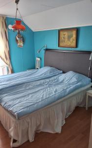 a bed in a room with a blue wall at Sundqvistens vinden in Emkarby