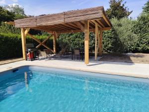 a pergola over a swimming pool with a table and chairs at Une histoire à écrire in Belleville-sur-Saône