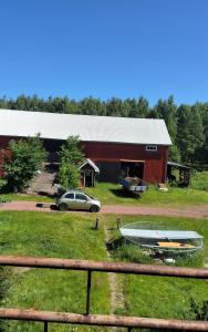 a car parked in front of a barn with a boat at Sundqvistens vinden in Emkarby