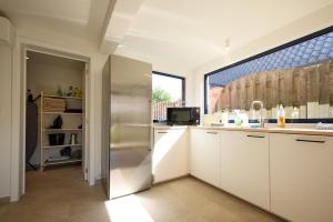 a kitchen with white cabinets and a stainless steel refrigerator at De Ontspannerij in Lille