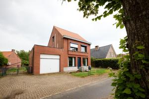 a brick house with a white garage at De Ontspannerij in Lille
