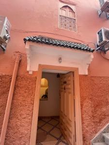 a doorway to a pink building with a roof at Riad Marrakech Palacito in Marrakesh