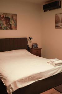 a bedroom with a bed with white sheets and a dresser at AleA Central Studio Art Museum in Craiova