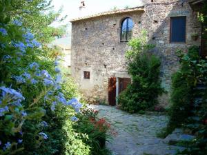 a stone building with a window and some flowers at il MOLENDINO in Calci