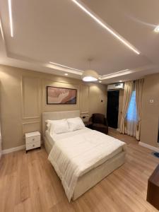 a bedroom with a large white bed and a chair at Pedro suite by iconic apartment in Lagos