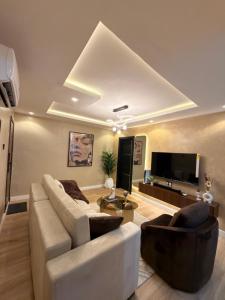 a living room with a couch and a flat screen tv at Pedro suite by iconic apartment in Lagos