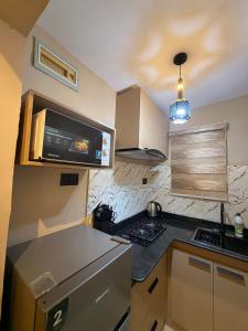 a small kitchen with a stove and a microwave at Pedro suite by iconic apartment in Lagos +2 photos