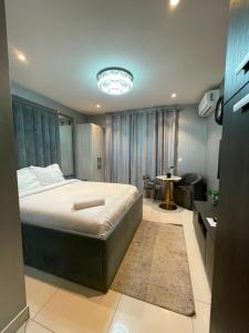 a bedroom with a large bed and a bathroom at The Lennox Premier Suites in Accra