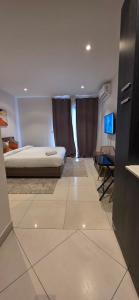 a bedroom with a bed and a television in it at The Lennox Premier Suites in Accra
