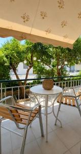 a table and chairs on a balcony with trees at Ioannis Schinas Studios in Loutra Edipsou