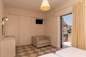 ein Hotelzimmer mit einem Stuhl und einem Fenster in der Unterkunft Galaxy New Hotel in Pylos