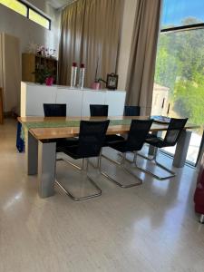 a dining table and chairs in a room with a large window at Villeni Panorama Apartment Oktonia in Okhthonía