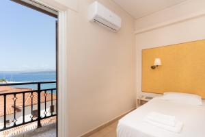 ein Schlafzimmer mit Bett und Meerblick in der Unterkunft Galaxy New Hotel in Pylos