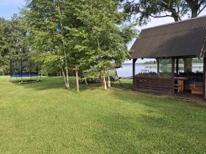 a picnic area with a tree and a pavilion at Camping "Sīvezers" in Auleja +14 photos