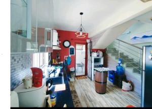 a kitchen with a red wall and a staircase at Georgios Villa in Grand-Baie