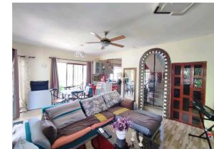a living room with a couch and a ceiling fan at Georgios Villa in Grand-Baie