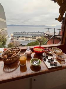 a table with various bowls of food on a balcony at Hostel Inn Bariloche in San Carlos de Bariloche