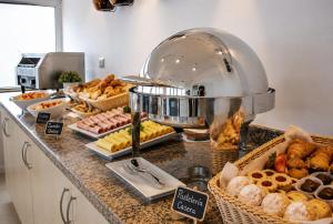 a buffet with various pastries and breads on a counter at Alto del Sol Costanera Antofagasta in Antofagasta +19 photos