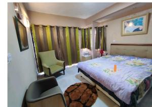 a bedroom with a large bed and a chair at Georgios Villa in Grand-Baie +11 photos