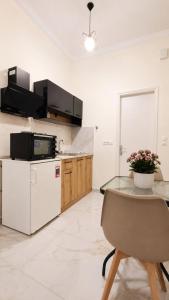 a kitchen with a white refrigerator and a table at Ioannis Schinas Studios in Loutra Edipsou +17 photos