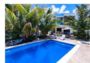 a swimming pool in front of a house with palm trees at Georgios Villa in Grand-Baie