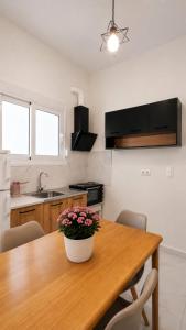 a kitchen with a wooden table with a pot of flowers on it at Ioannis Schinas Studios in Loutra Edipsou