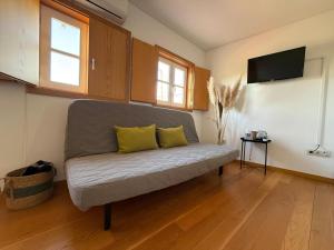 a couch with two yellow pillows in a living room at Castelo 48 in Lamego