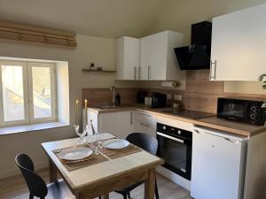 a kitchen with a wooden table and a small table with chairs at Bulles et cocon in La Roche-Bernard
