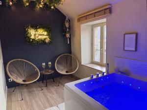 a bathroom with a blue tub and two chairs at Bulles et cocon in La Roche-Bernard