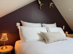 a bedroom with a white bed with a black wall at Bulles et cocon in La Roche-Bernard +4 photos