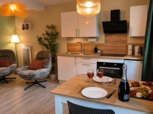 a kitchen with a table and two glasses of wine at Bulles et cocon in La Roche-Bernard
