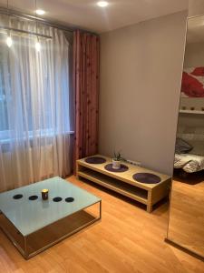 a room with a bed and a glass table at Dzirciema apartment in Riga