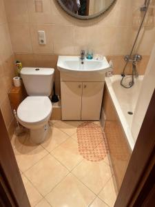 a bathroom with a toilet and a sink and a tub at Dzirciema apartment in Riga