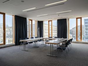 a conference room with tables and chairs and windows at Novotel Karlsruhe City in Karlsruhe