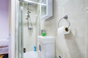 a bathroom with a shower and a toilet and a sink at The City Hotel London in London