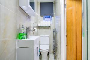 a bathroom with a white toilet and a sink at The City Hotel London in London