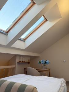 a skylight in a bedroom with a bed and a desk at OrkanaApart in Nowy Targ