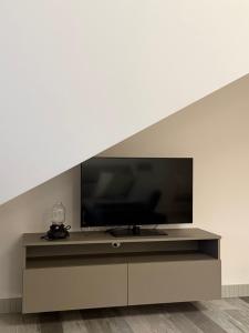 a flat screen tv sitting on a entertainment center under a staircase at OrkanaApart in Nowy Targ