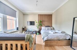 a bedroom with two beds and a tv at Chic Flat Hideaway with Private Courtyard - Pass the Keys in Guildford