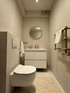 a bathroom with a white toilet and a sink at OrkanaApart in Nowy Targ +9 photos