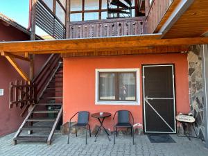 a patio with three chairs and a table next to a building at Pensiunea Melinda in Praid